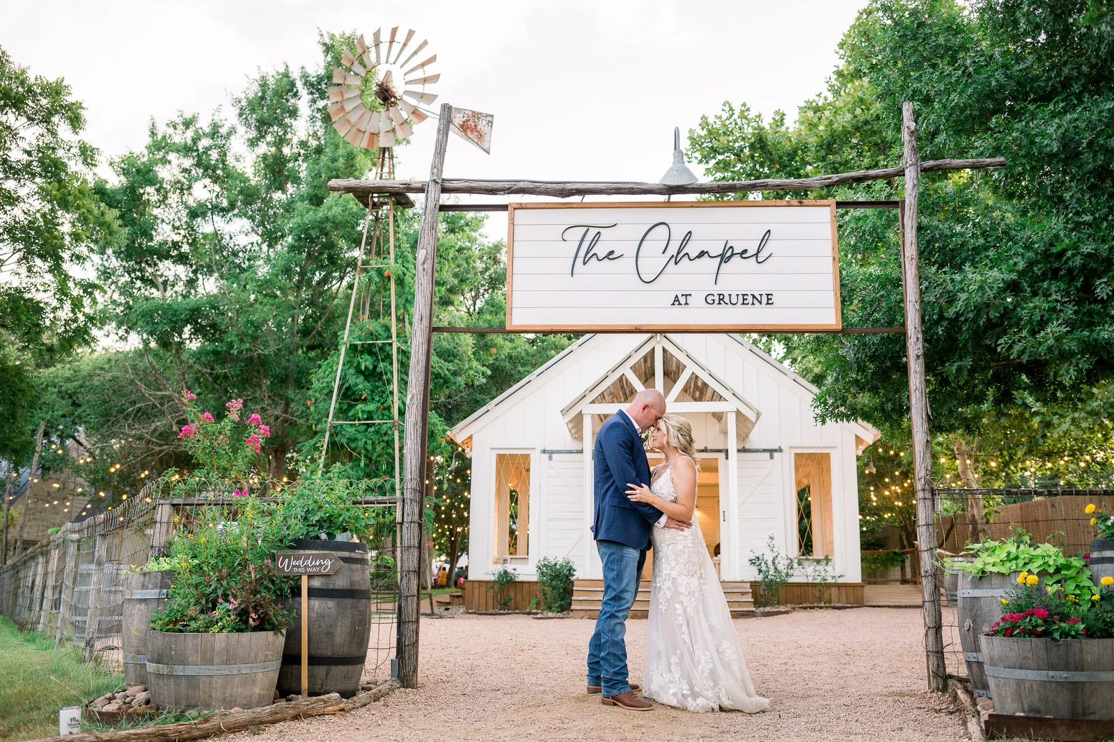 A couple beneath The Chapel at Gruene entrance sign